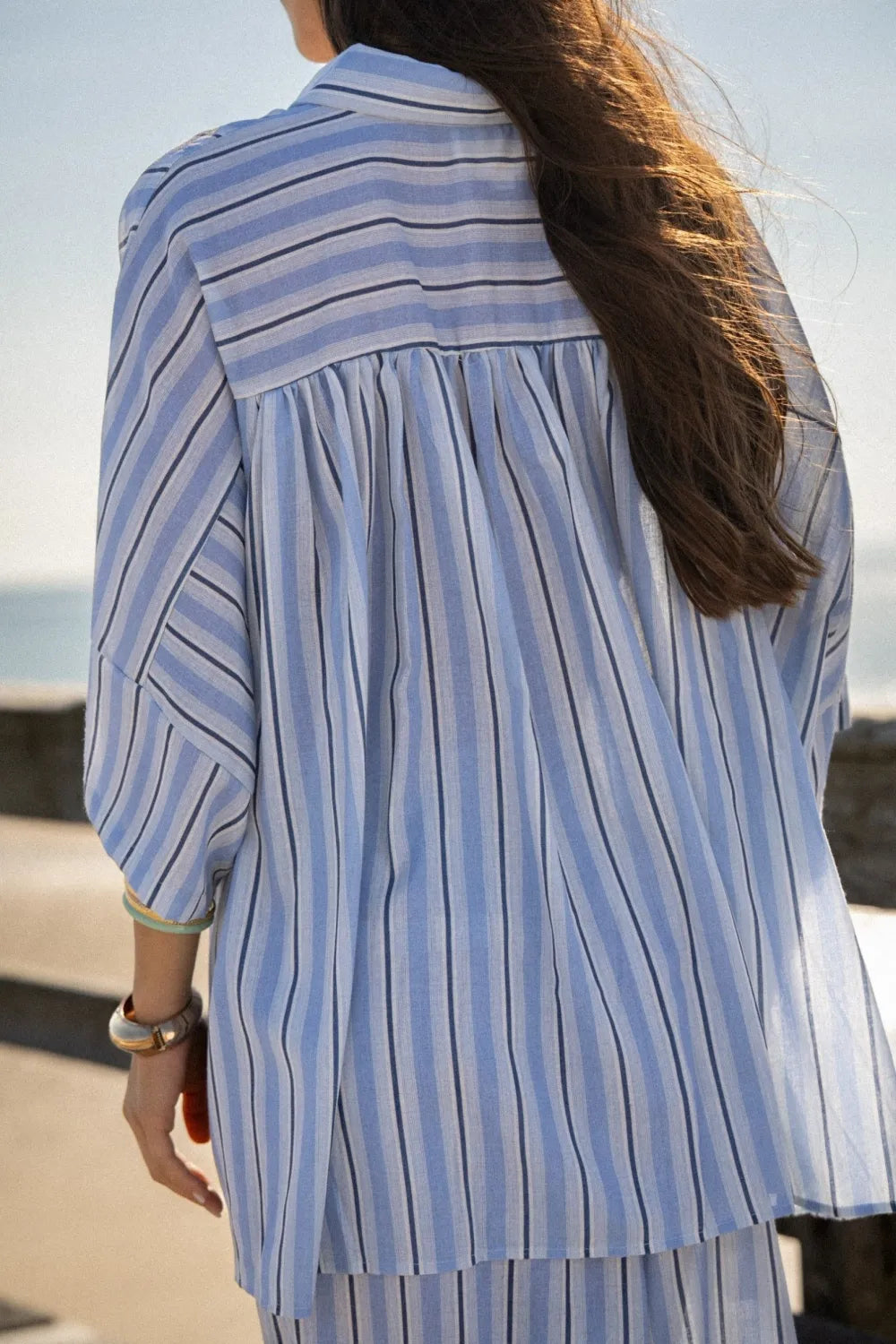 Dos froncé de la chemise rayée bleue de l’ensemble Blandine